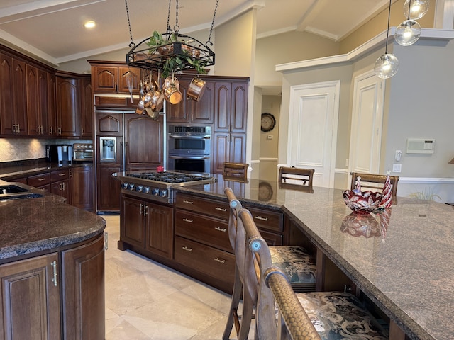 kitchen featuring lofted ceiling, stainless steel appliances, dark brown cabinets, and dark stone countertops