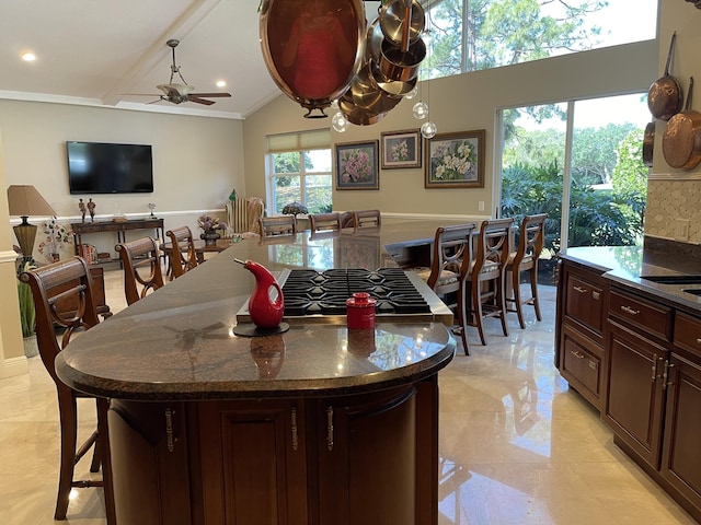 dining space with ceiling fan, ornamental molding, and vaulted ceiling