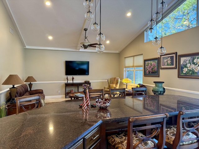 kitchen with high vaulted ceiling, dark stone countertops, hanging light fixtures, ceiling fan, and dark brown cabinets