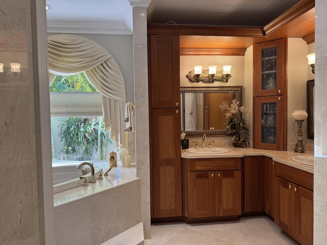 bathroom with decorative columns, crown molding, vanity, tile patterned flooring, and a washtub