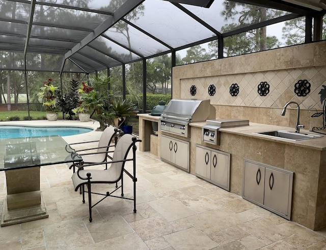 view of patio with area for grilling, sink, a grill, and glass enclosure