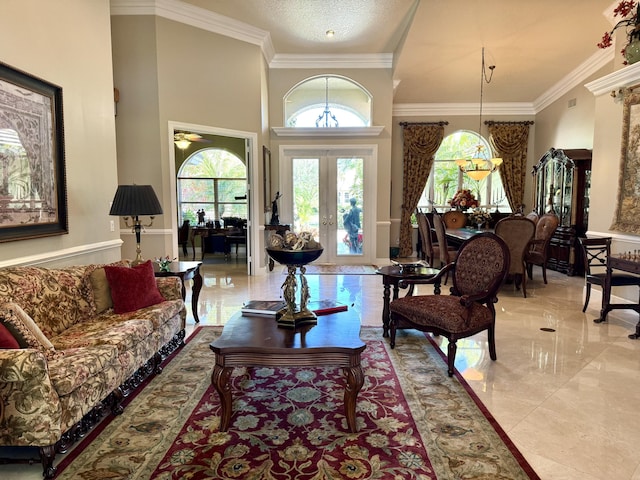 living room featuring crown molding, a towering ceiling, and french doors