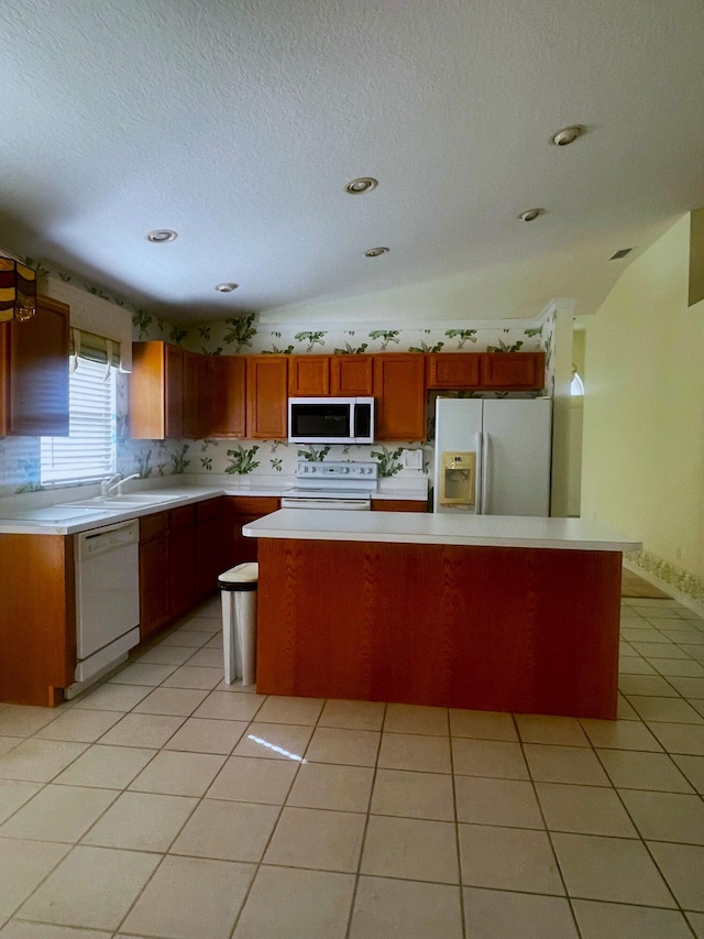 kitchen featuring a center island, a textured ceiling, vaulted ceiling, white appliances, and light tile patterned floors