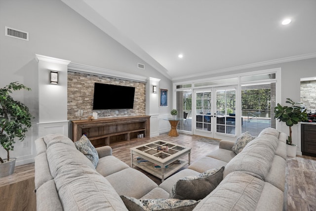 living room featuring lofted ceiling, french doors, ornamental molding, and wood-type flooring