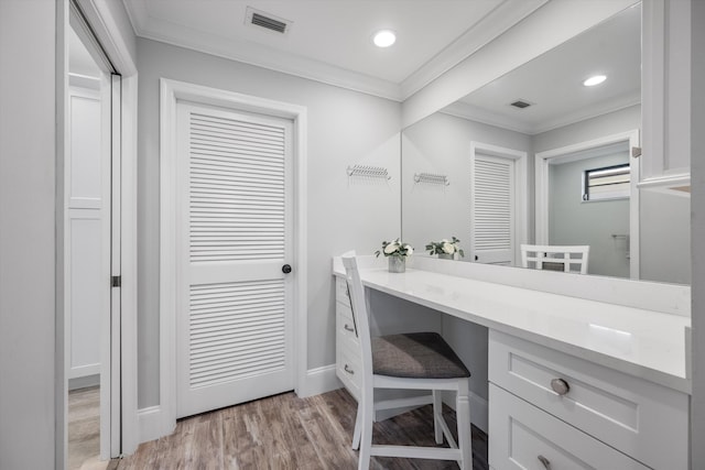 bathroom with ornamental molding, vanity, and hardwood / wood-style floors