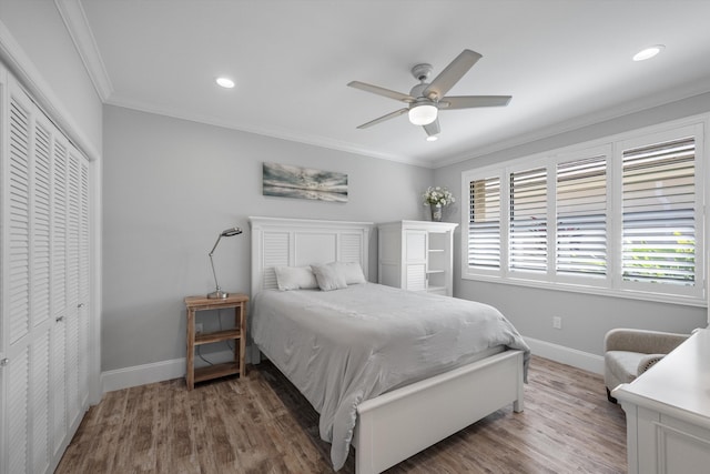 bedroom featuring dark hardwood / wood-style flooring, a closet, ceiling fan, and crown molding