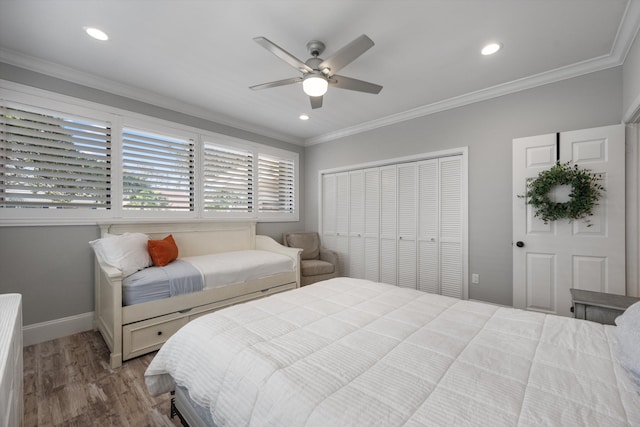 bedroom with ceiling fan, a closet, crown molding, and wood-type flooring