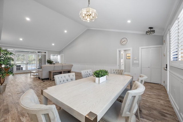 dining area featuring light hardwood / wood-style flooring, crown molding, french doors, and lofted ceiling