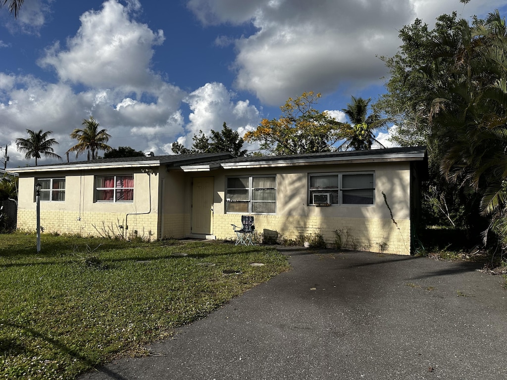 view of front of house with cooling unit and a front yard