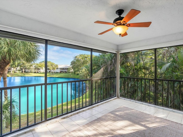 unfurnished sunroom featuring ceiling fan, a healthy amount of sunlight, and a water view