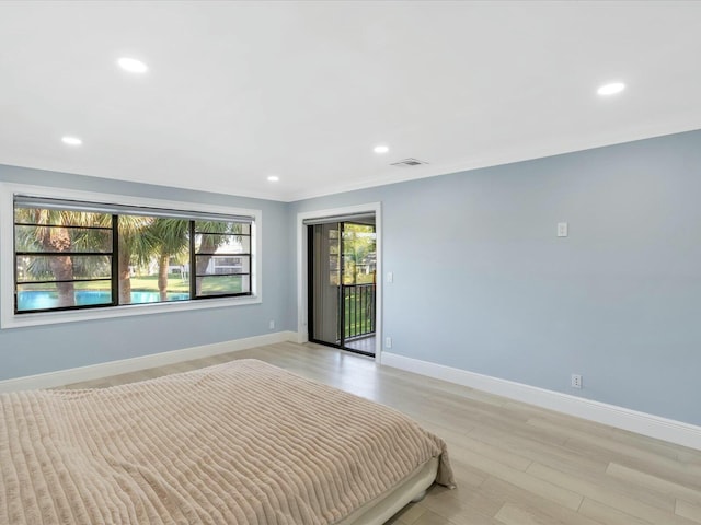 unfurnished bedroom featuring access to exterior and light hardwood / wood-style flooring