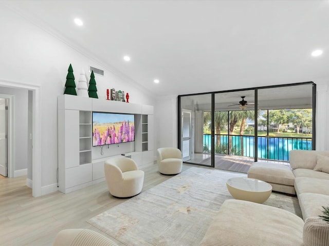 living room featuring lofted ceiling, expansive windows, light hardwood / wood-style flooring, ceiling fan, and ornamental molding