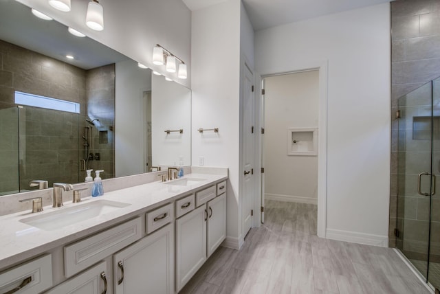 bathroom with hardwood / wood-style floors, vanity, and walk in shower