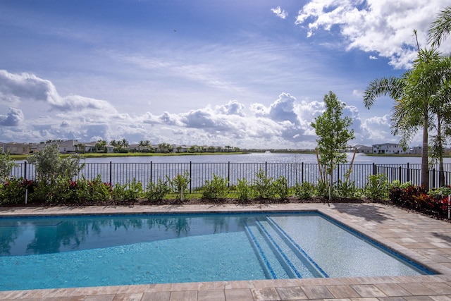 view of swimming pool with a water view and a patio