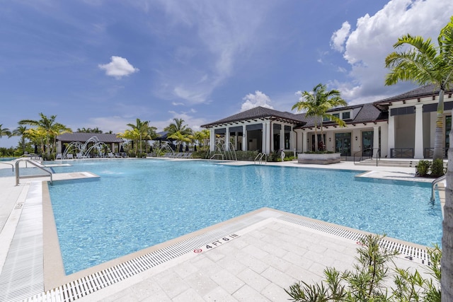 view of swimming pool with pool water feature and a patio