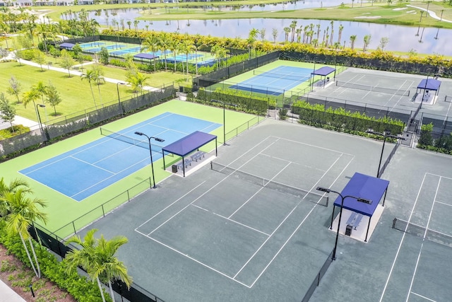 view of sport court with basketball hoop and a water view