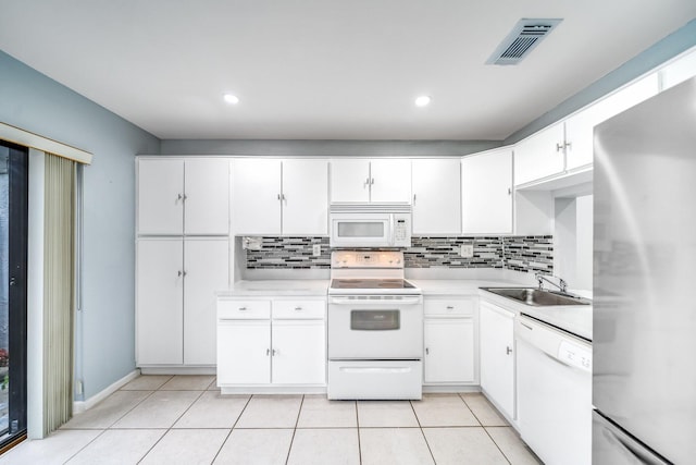 kitchen with tasteful backsplash, sink, white cabinets, and white appliances