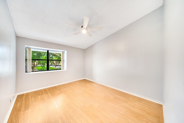 unfurnished room featuring a textured ceiling, ceiling fan, vaulted ceiling, and hardwood / wood-style flooring