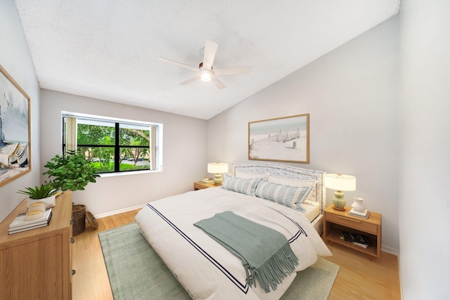 bedroom with vaulted ceiling, light hardwood / wood-style flooring, and ceiling fan