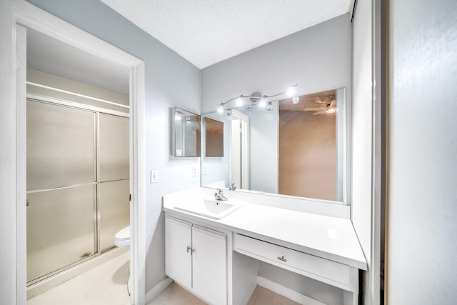 bathroom with a textured ceiling, vanity, toilet, and walk in shower