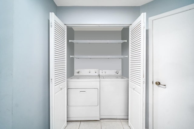 laundry area with washer and dryer and light tile patterned floors