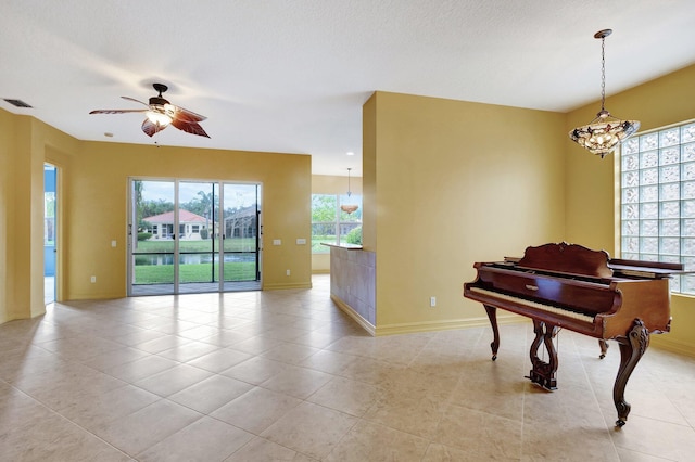 misc room featuring light tile patterned floors, a wealth of natural light, and ceiling fan