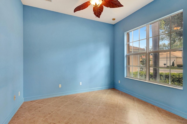 empty room featuring ceiling fan and plenty of natural light