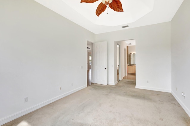 10623 Silverton Ln, Boynton Beach, FL 33437 - unfurnished bedroom with light carpet, baseboards, connected bathroom, a ceiling fan, and a tray ceiling