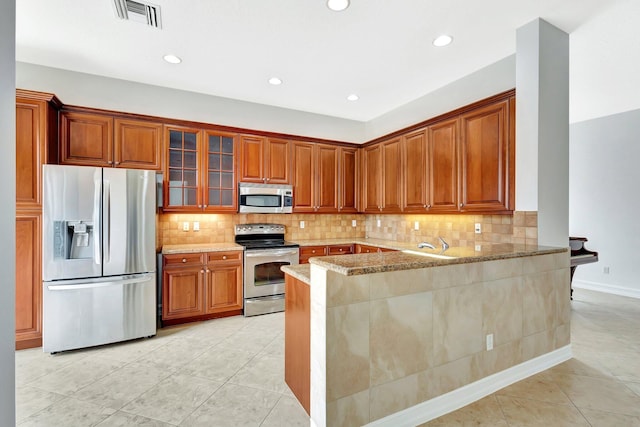 10623 Silverton Ln, Boynton Beach, FL 33437 - kitchen with stainless steel appliances, light tile patterned floors, glass insert cabinets, decorative backsplash, and recessed lighting