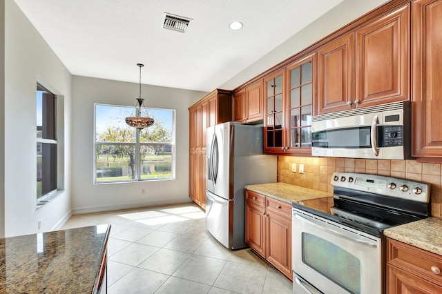 10623 Silverton Ln, Boynton Beach, FL 33437 - kitchen with stainless steel appliances, backsplash, glass insert cabinets, hanging light fixtures, and recessed lighting