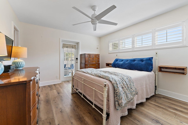 bedroom with multiple windows, wood-type flooring, access to exterior, and ceiling fan