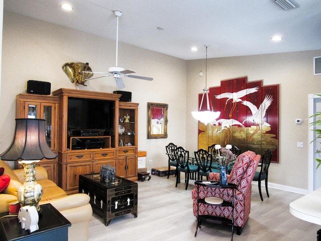 living room with ceiling fan and light hardwood / wood-style flooring