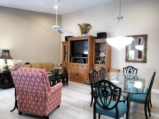 dining space with ceiling fan and light hardwood / wood-style flooring