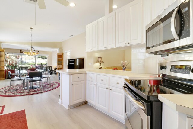 kitchen with stainless steel appliances, white cabinetry, ceiling fan, kitchen peninsula, and hanging light fixtures