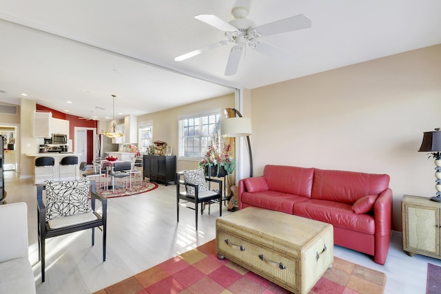 living room with ceiling fan, lofted ceiling, and light hardwood / wood-style flooring