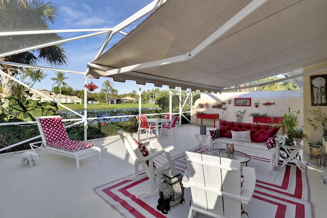 view of patio / terrace with an outdoor living space, a lanai, and a water view