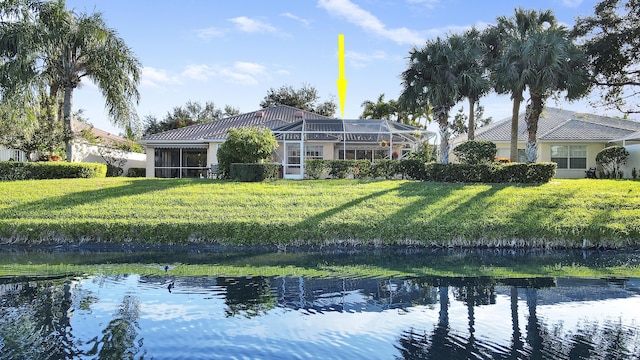 back of property featuring a lawn and a water view