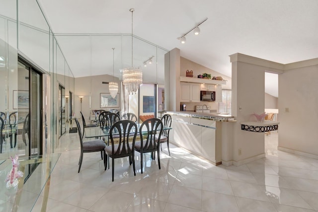 tiled dining space with lofted ceiling and a chandelier