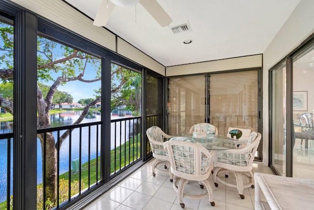 sunroom featuring a water view and ceiling fan