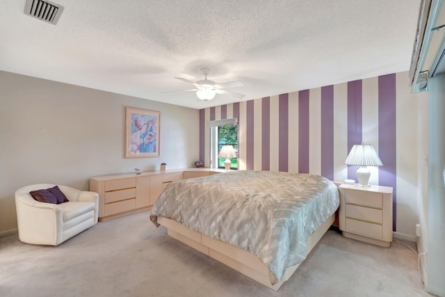 carpeted bedroom with a textured ceiling and ceiling fan