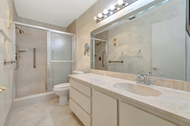 bathroom featuring a shower with door, vanity, tile patterned floors, and toilet