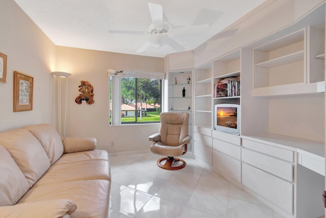 tiled living room with a fireplace, built in features, and ceiling fan