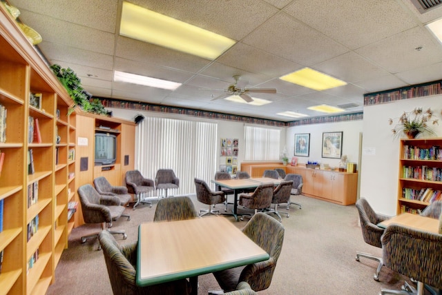 office area featuring a drop ceiling, carpet floors, and ceiling fan