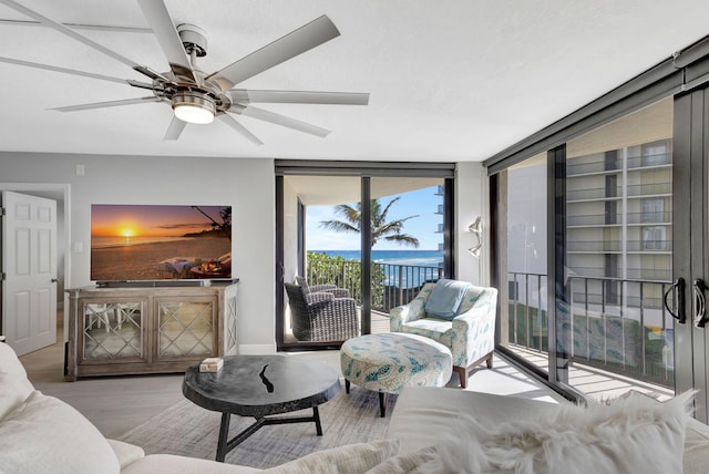 living room with hardwood / wood-style floors, floor to ceiling windows, and ceiling fan