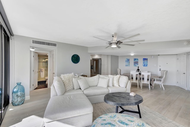 living room with light wood-type flooring and ceiling fan