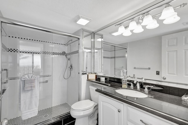 bathroom with vanity, toilet, a textured ceiling, and walk in shower