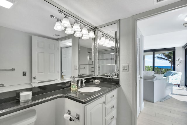 bathroom with vanity, toilet, and a textured ceiling