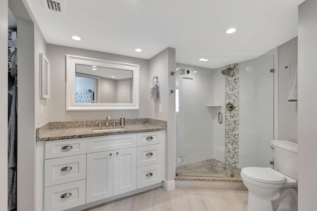 bathroom featuring vanity, toilet, and an enclosed shower