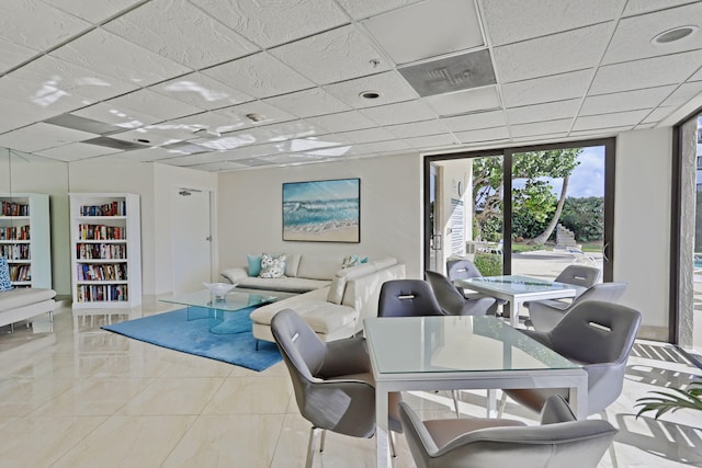 interior space with a paneled ceiling and floor to ceiling windows