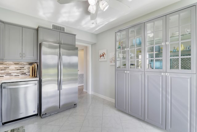 kitchen with appliances with stainless steel finishes, tasteful backsplash, ceiling fan, and gray cabinetry